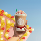 Colorful Starbucks Frappucino held up over carnival background